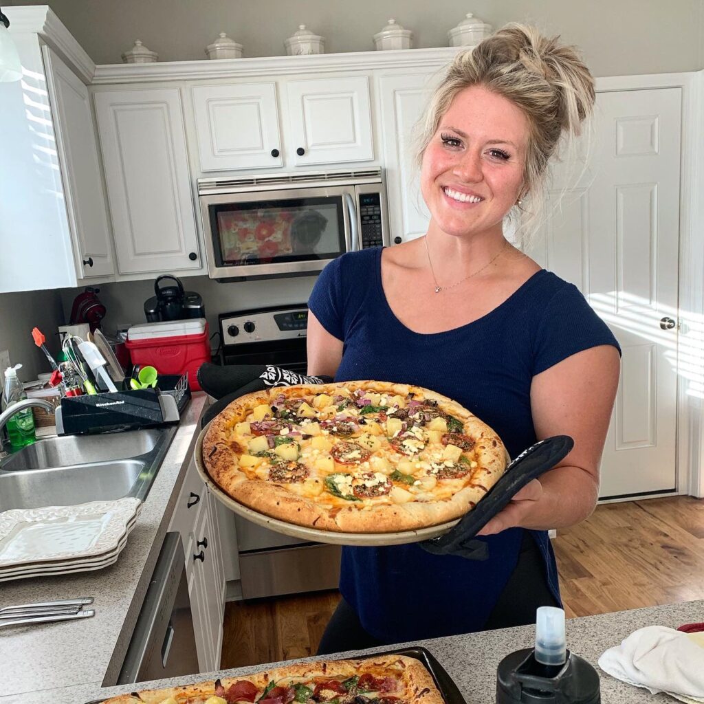 city girl becomes a homesteader Holding a homemade sourdough pizza