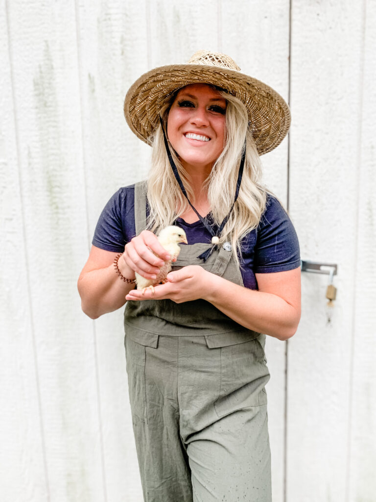 City girl becomes a homesteader holding a cornish broiler hen 